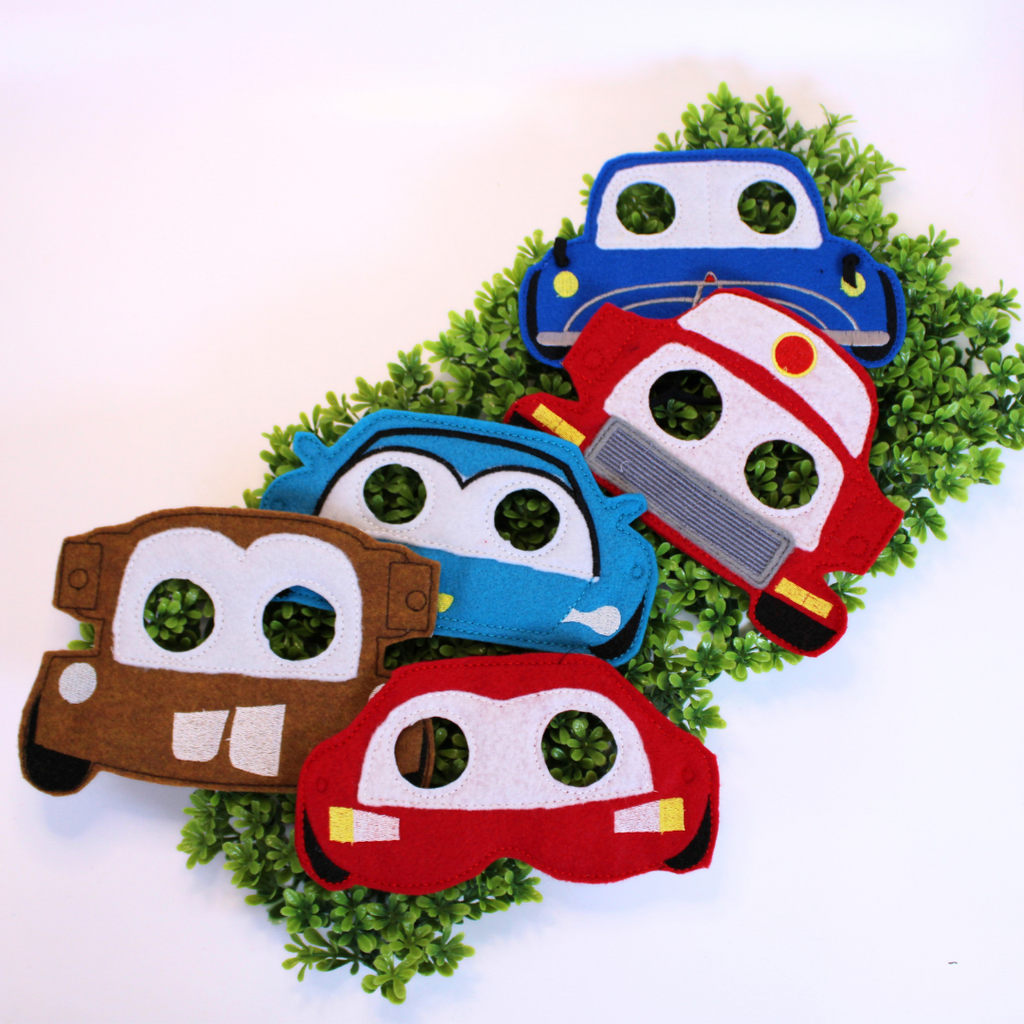Set of colorful car-shaped masks on a green wreath against a white background