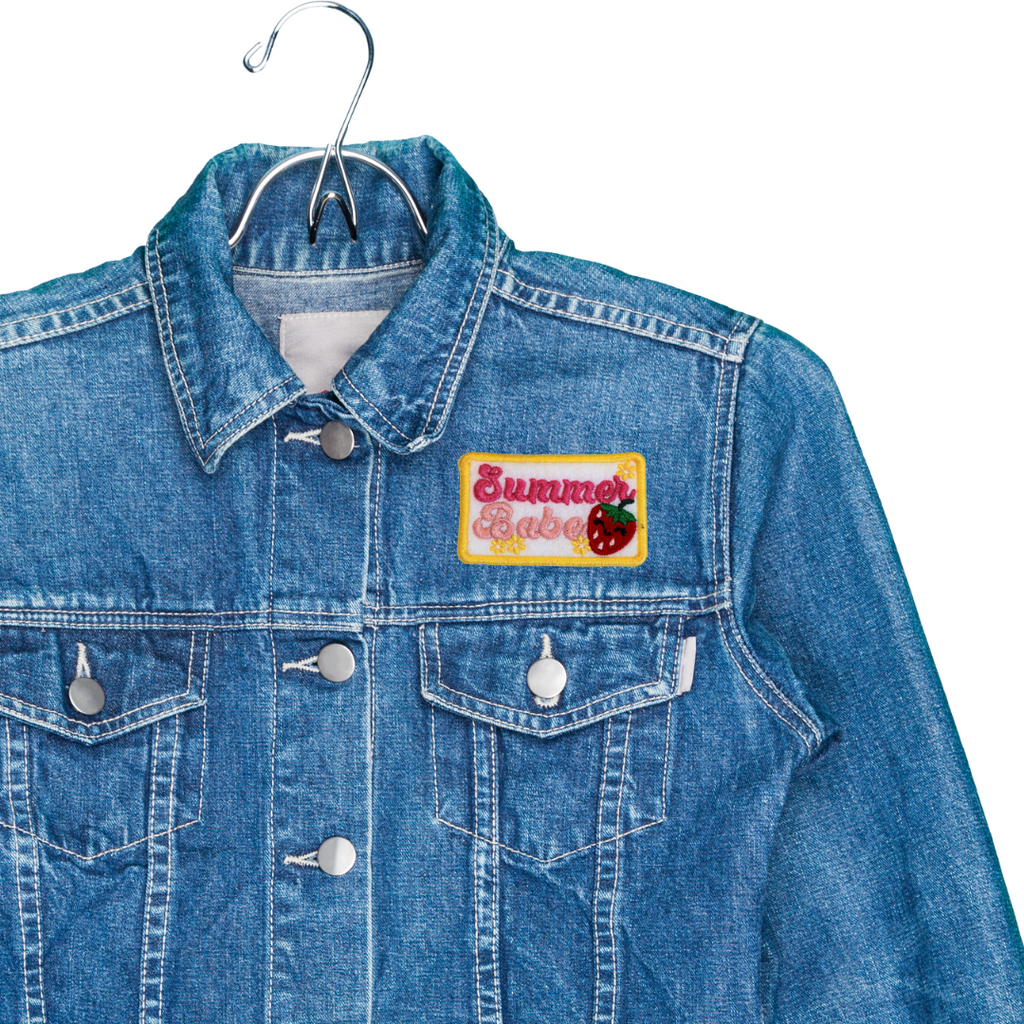 Blue denim jacket with a 'Summer Babe' patch on a white background
