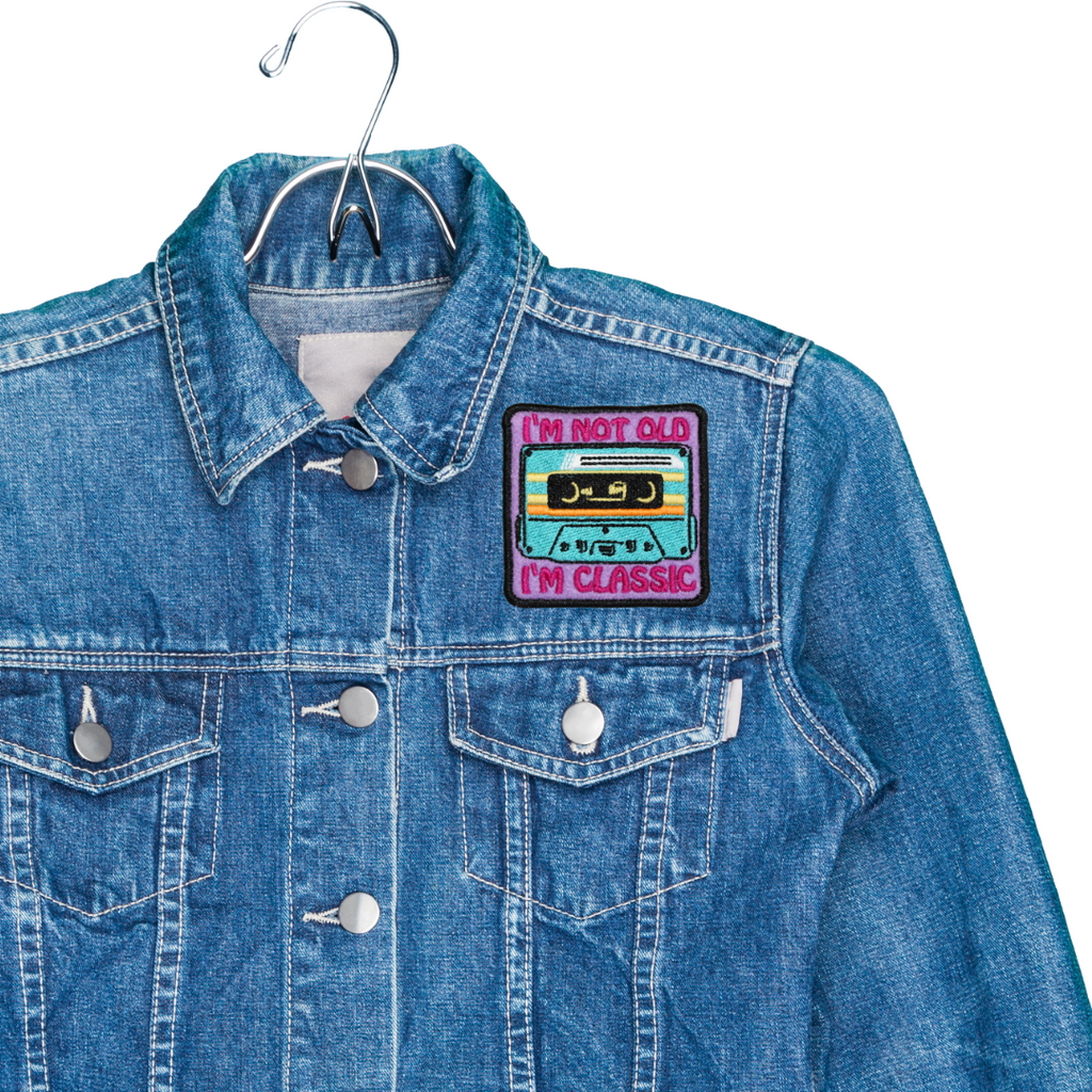 Blue denim jacket with a patch on a white background