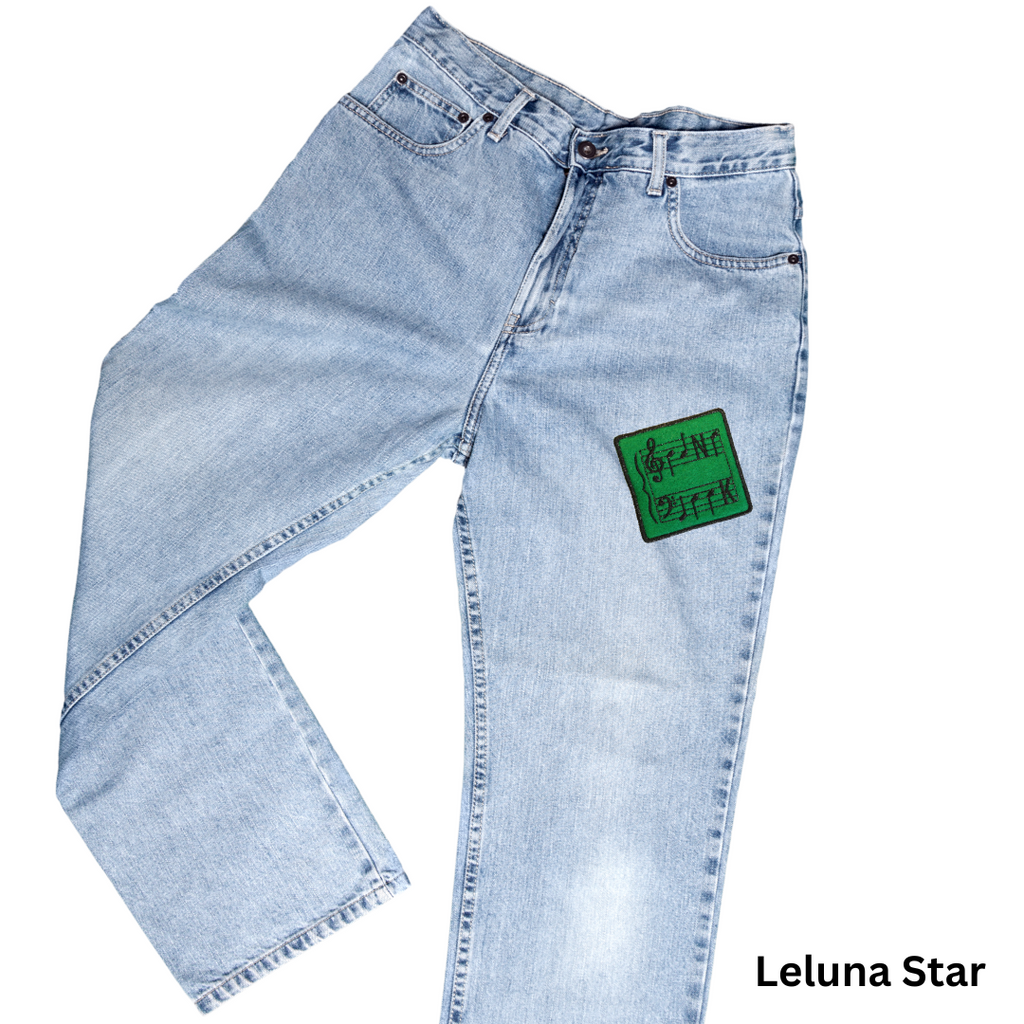 Light blue jeans with a green patch on a white background