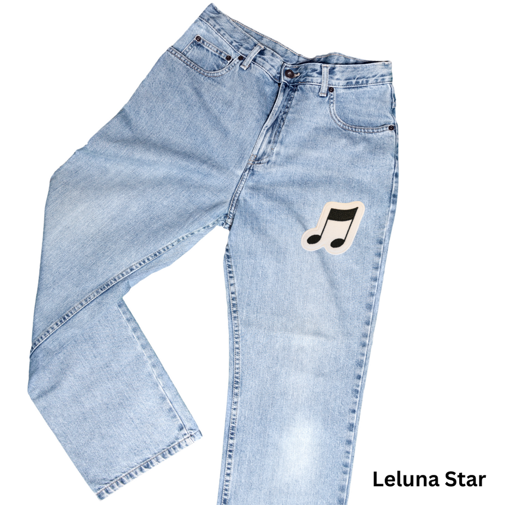 Light blue jeans with a music note patch on a white background