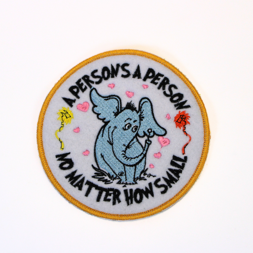 Circular patch with an elephant illustration and text on a white background