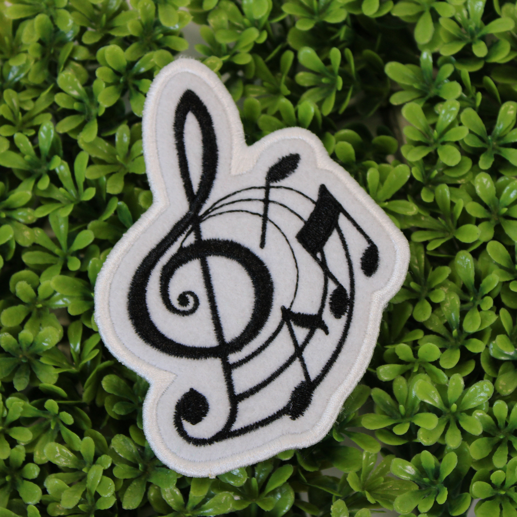 Music-themed patch with treble clef and notes on a green leaf background
