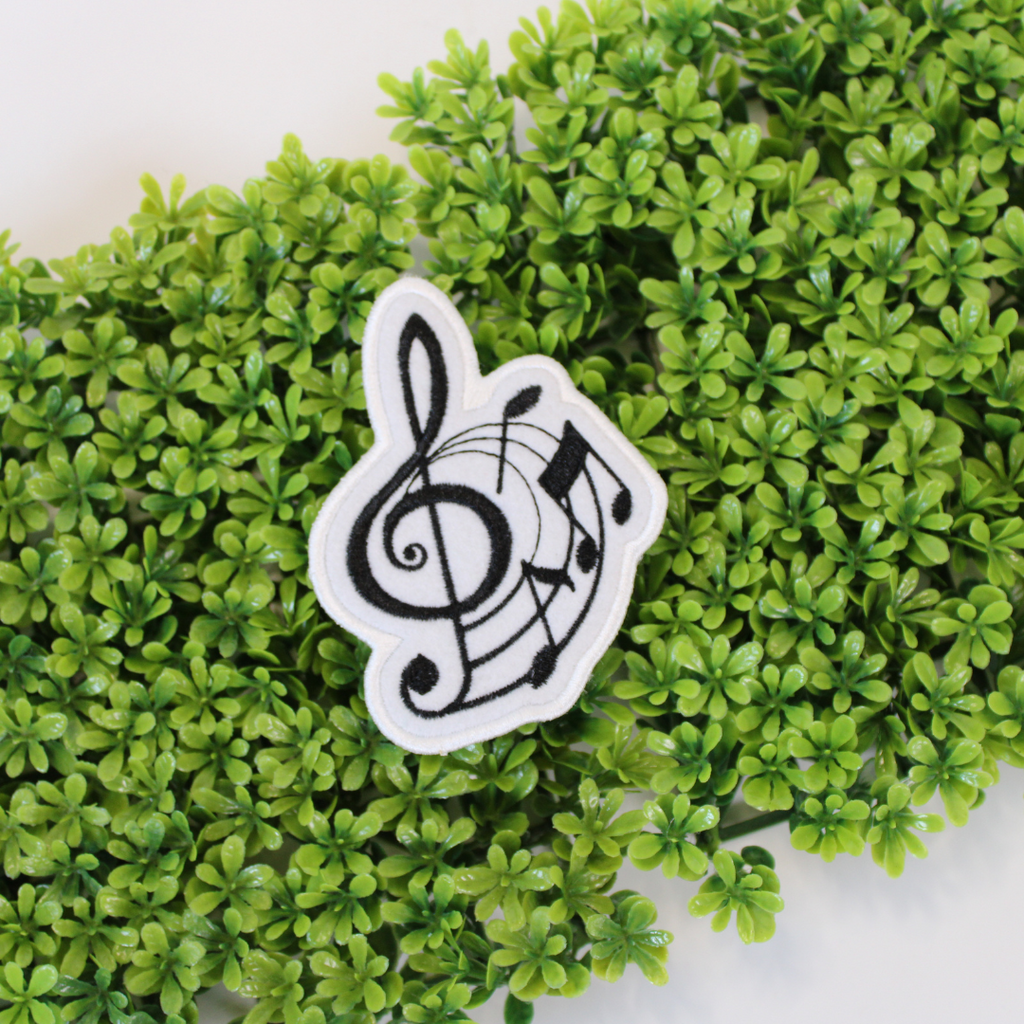 Music note design on a white patch against a green leafy background