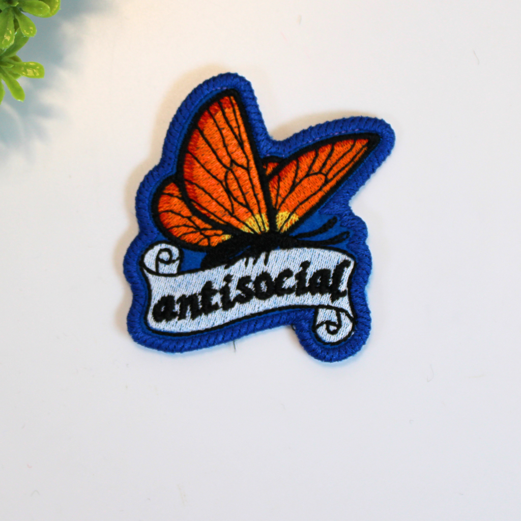 Patch with butterfly design and 'antisocial' text on a white background
