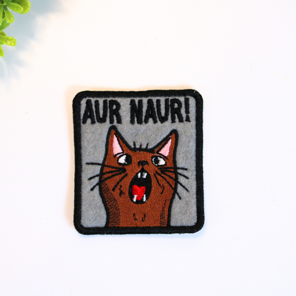 Embroidered patch with a cat illustration and text 'AUR NAUR!' on a white background
