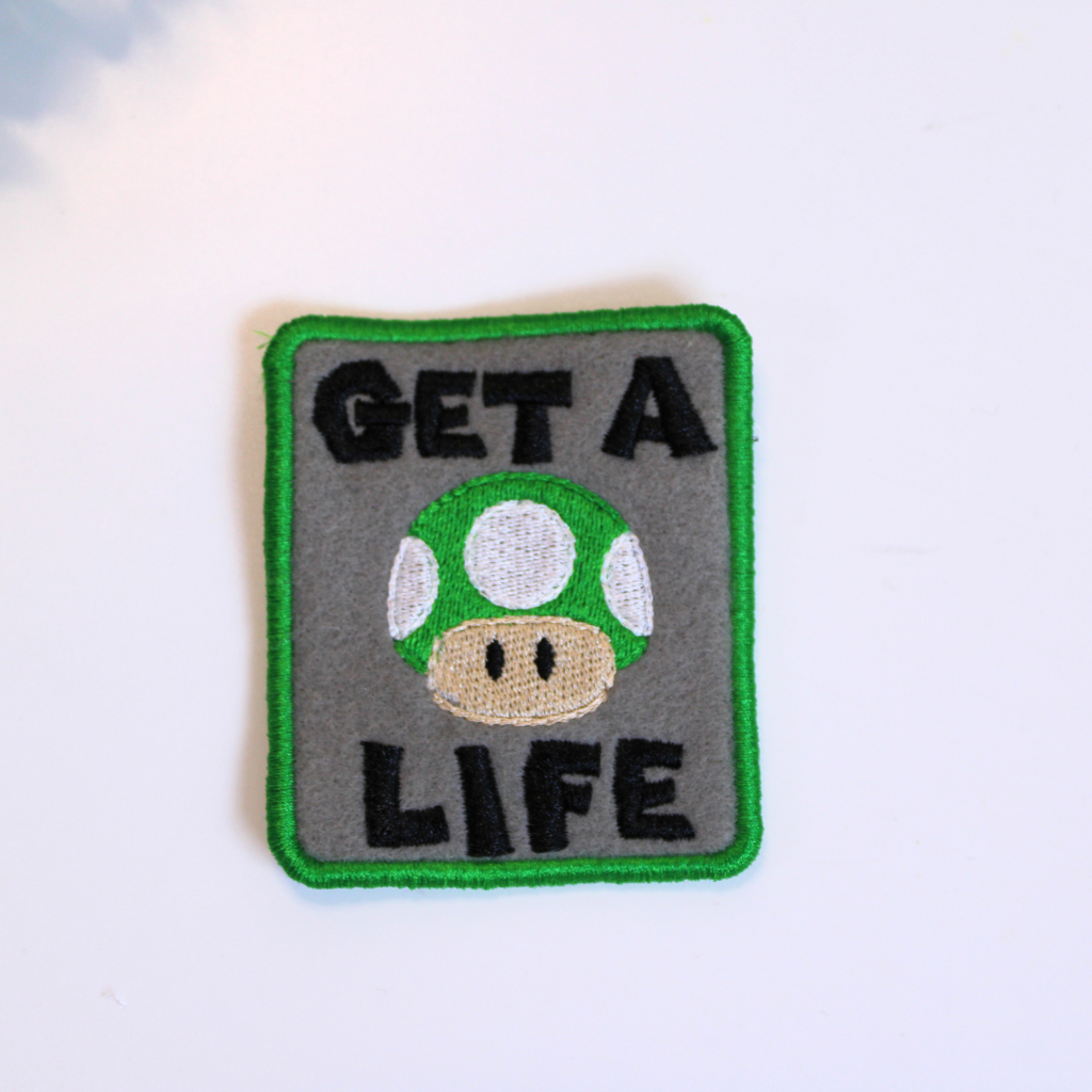 Patch with mushroom design and 'GET A LIFE' text on a white background