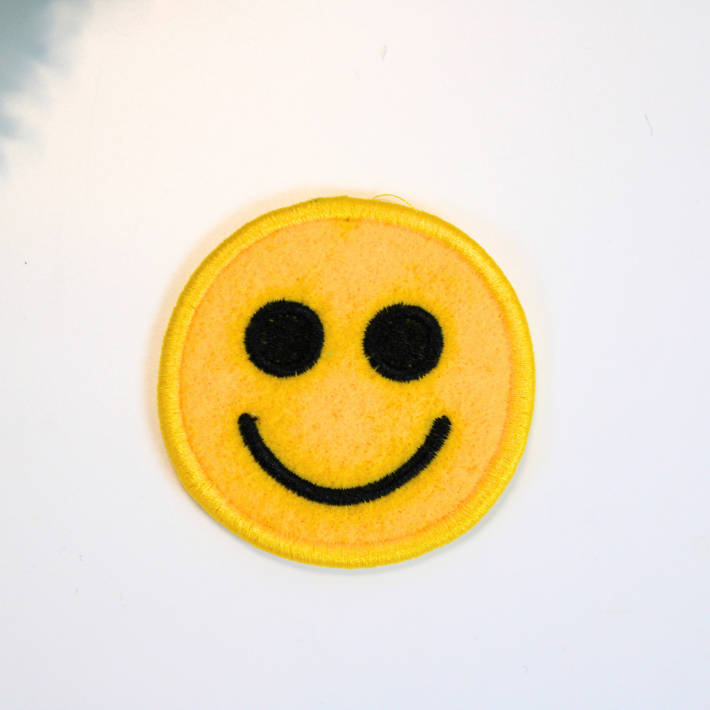 Smiley face patch on a white background