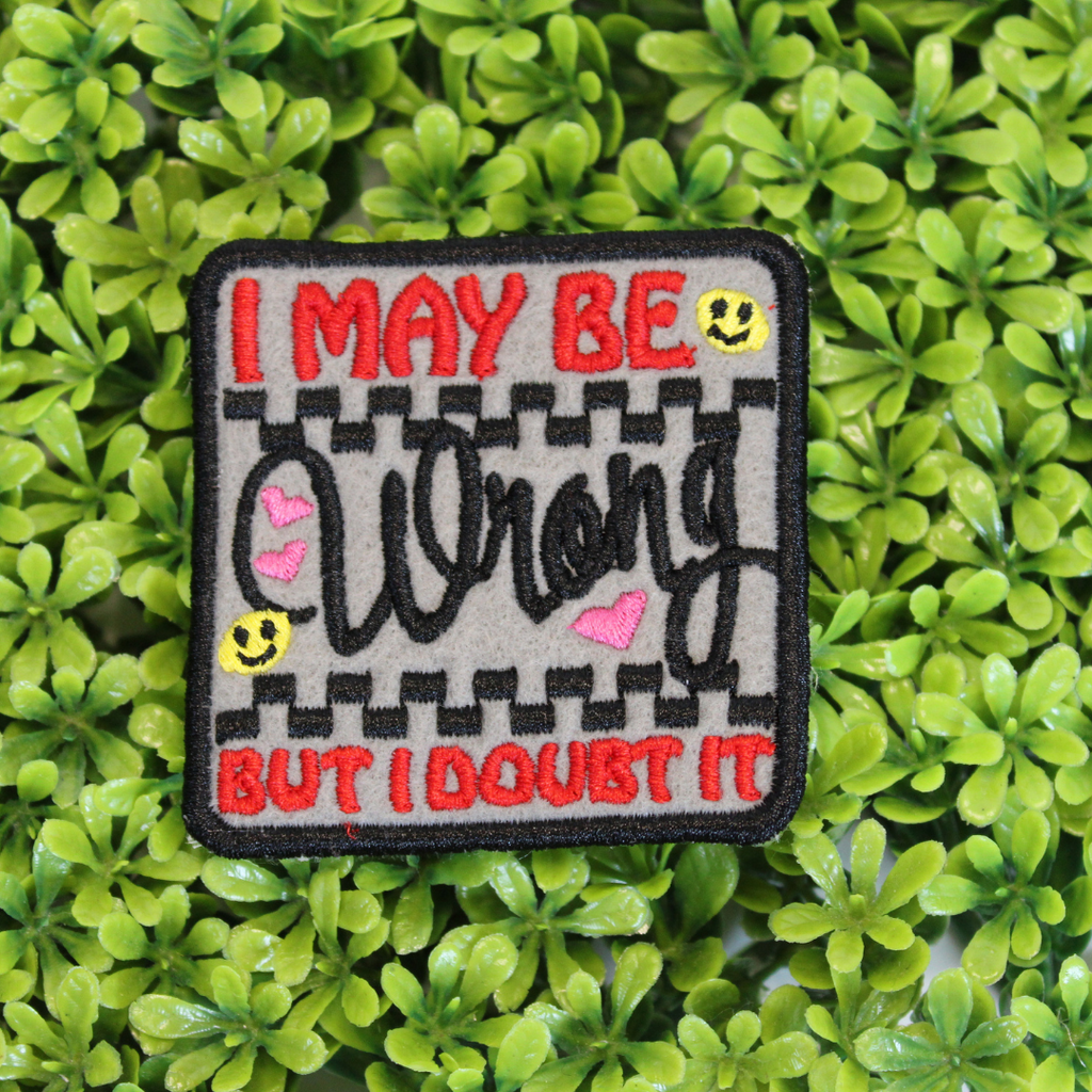 Patch with text 'I MAY BE WRONG BUT I DOUBT IT' on a green leaf background