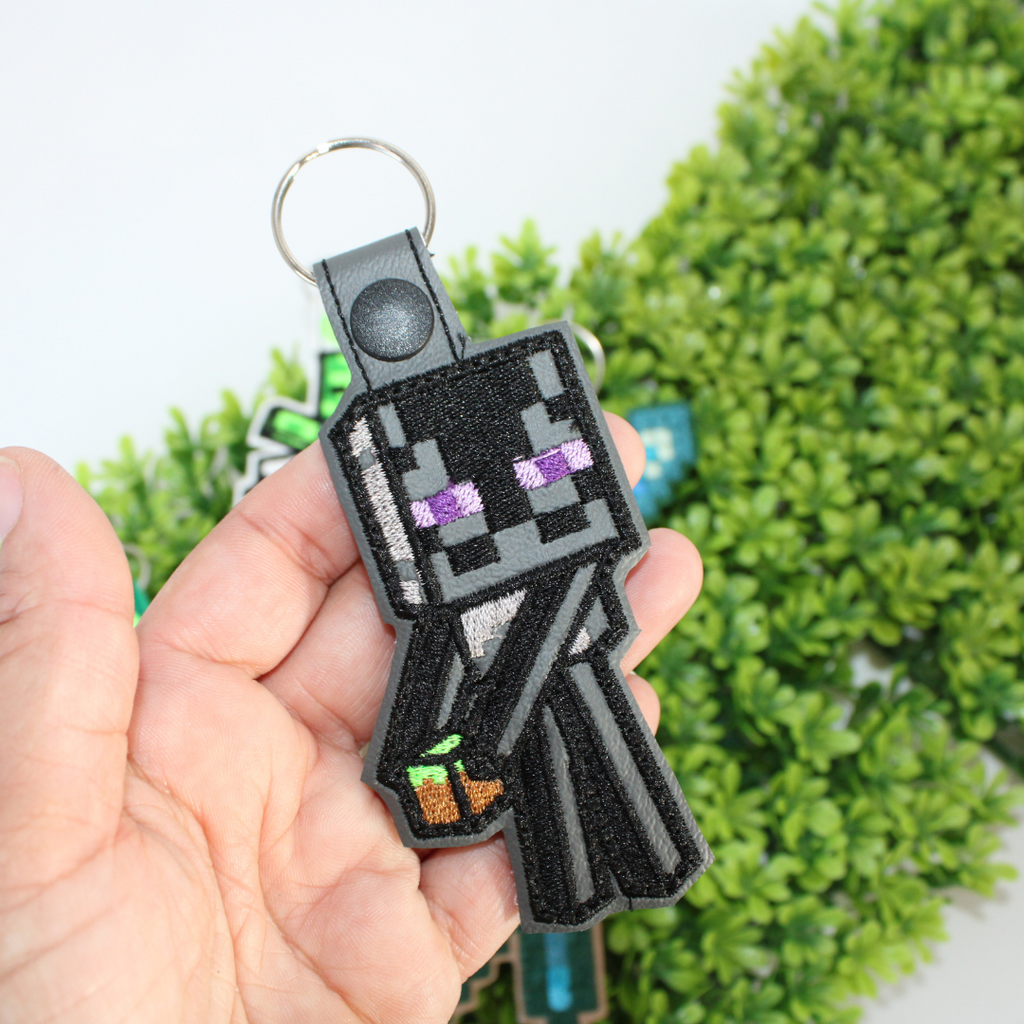 Set of Minecraft-themed keychains on a green leaf background